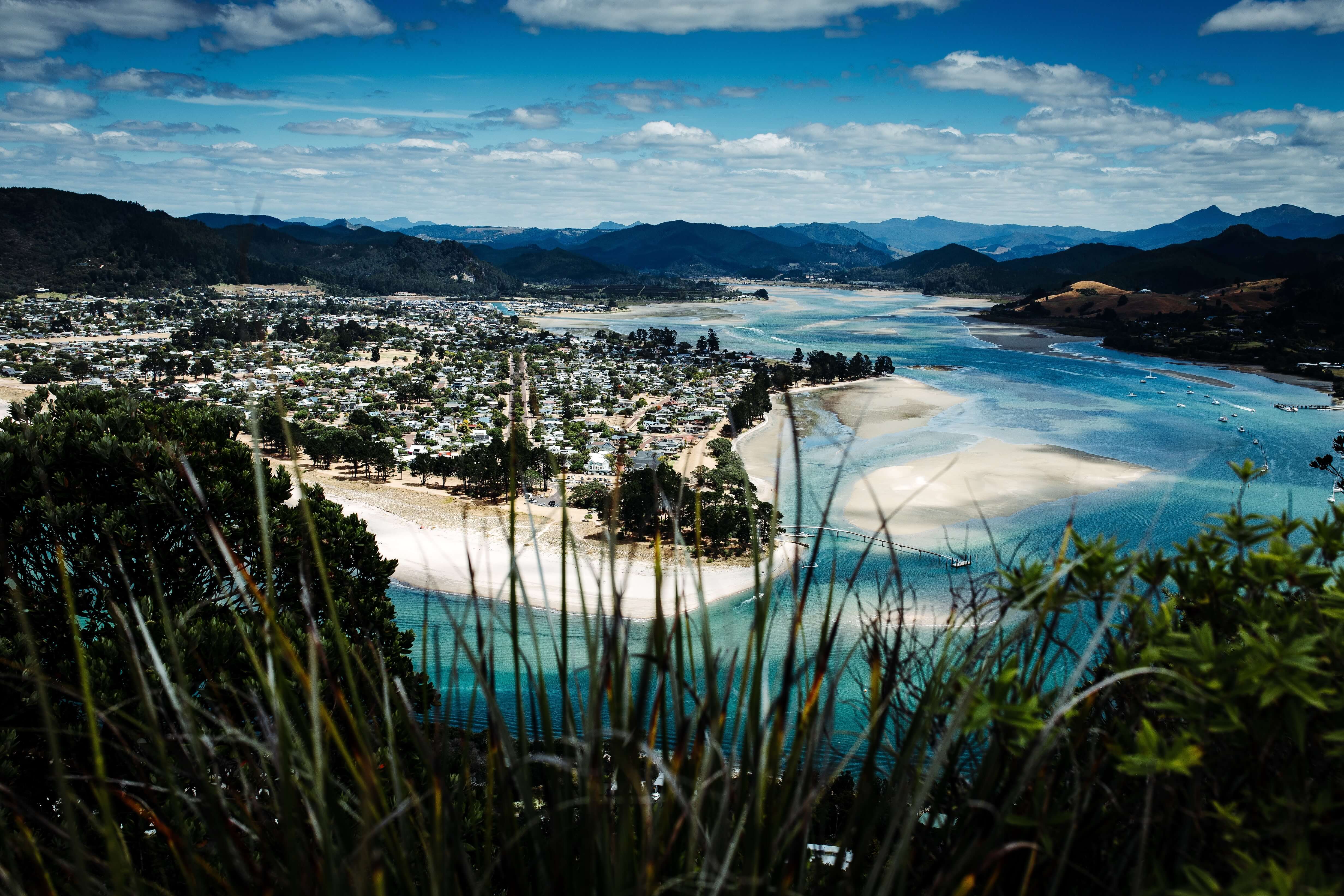 Image taken from hill tops overlooking a town and beach in the Coromandel