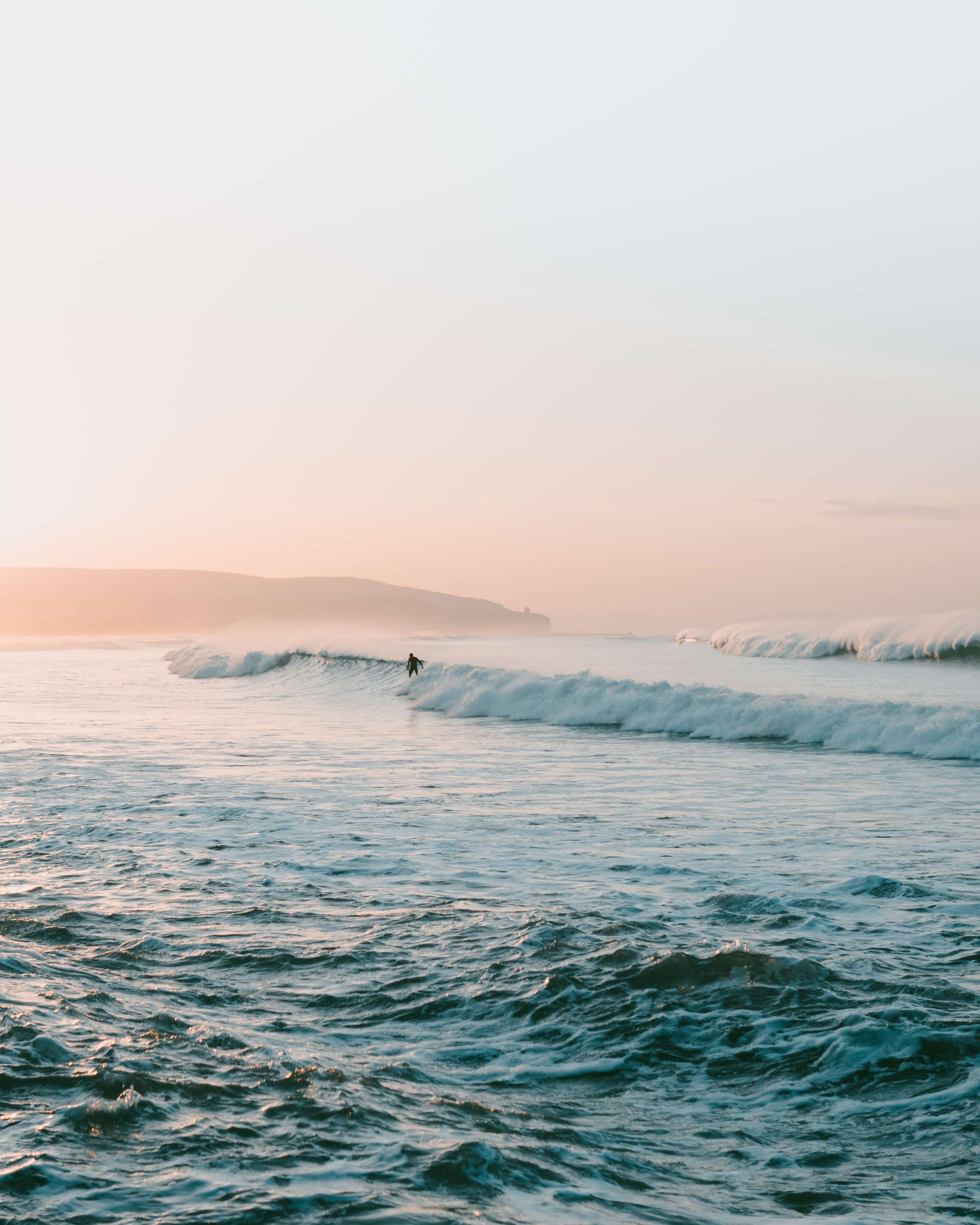 Wave breaking with a surfer riding along with his back facing the camera