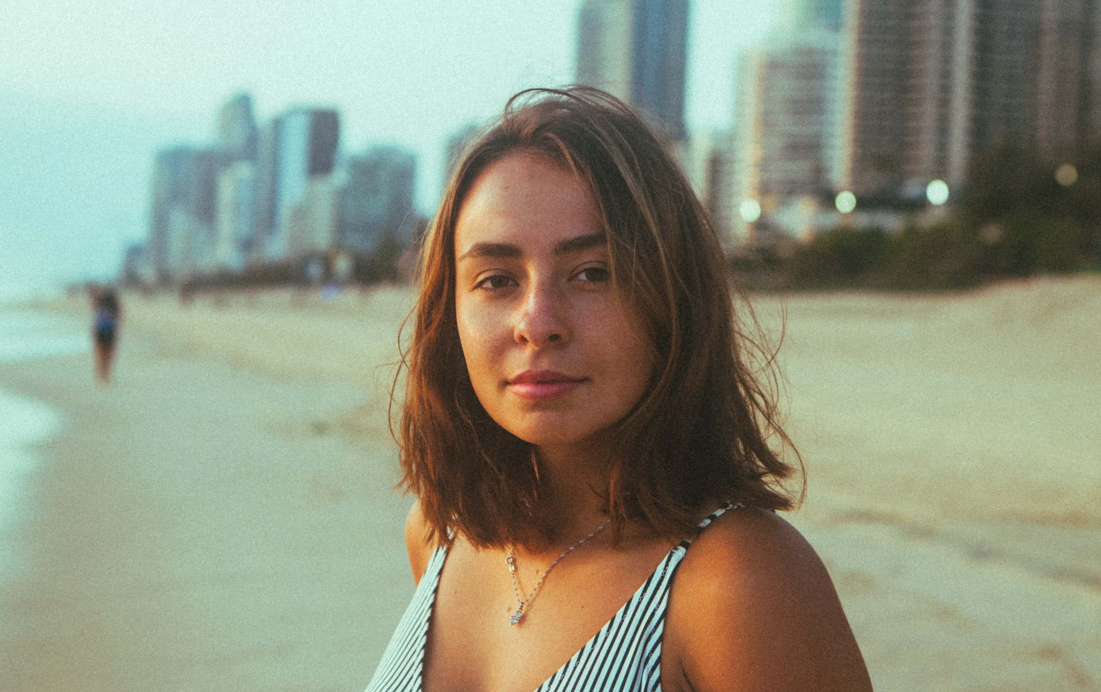 Head shot of a brunette woman standing on the beach
